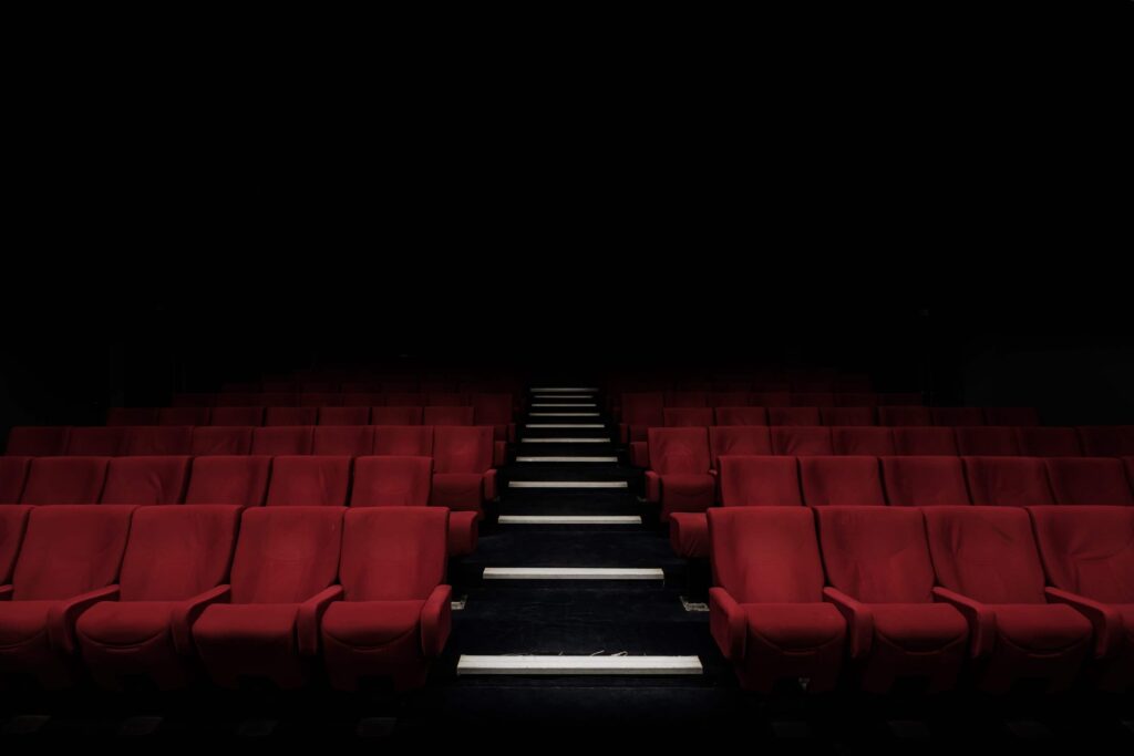 En tom biografsal med en masse røde sæder.